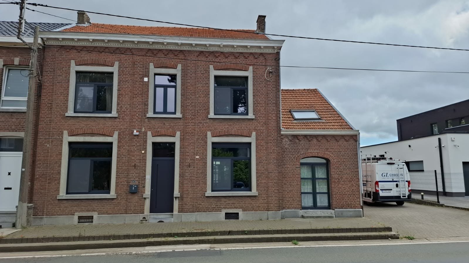 Maison de ville en brique rénovée avec châssis et porte gris foncé