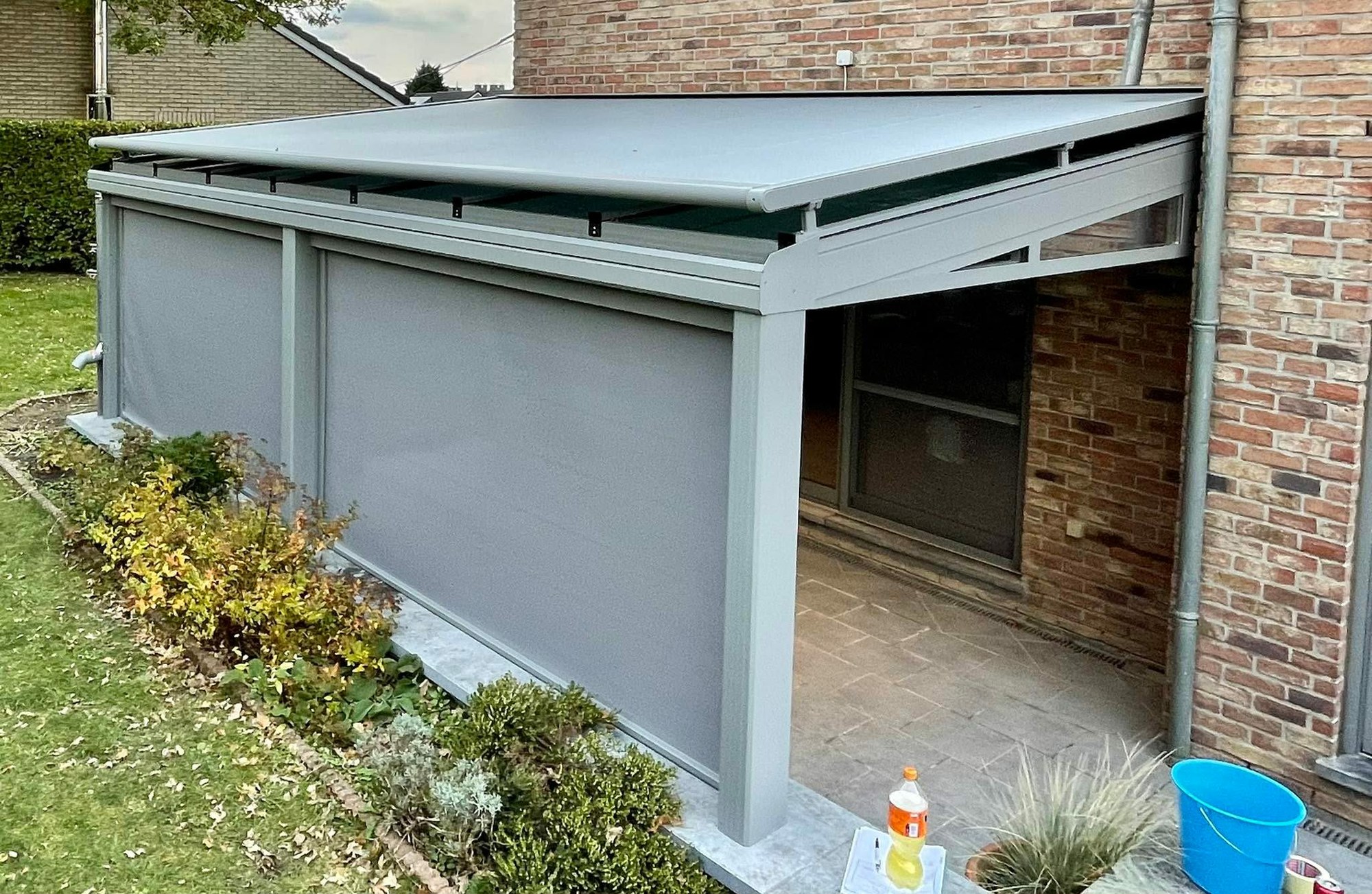 Pergola anthracite équipée de screens latéraux descendus