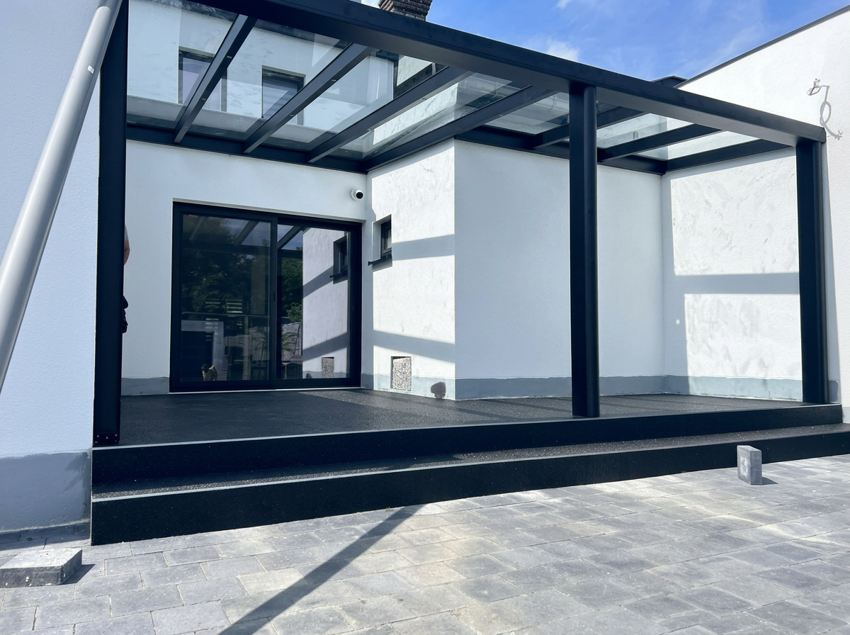 Après travaux — Cour intérieure transformée par une pergola vitrée noire