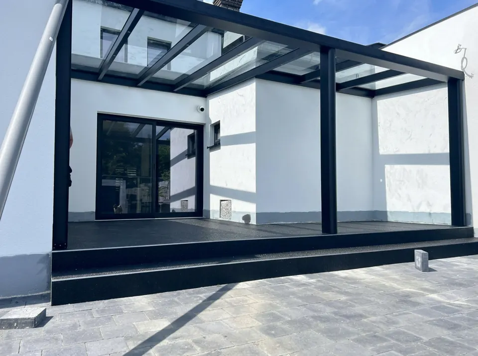Après travaux — Cour intérieure transformée par une pergola vitrée noire